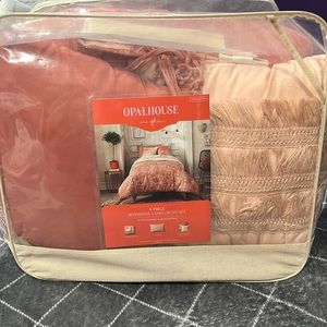 Orangish pink bedding with comforter, and two throw blankets and sheets
